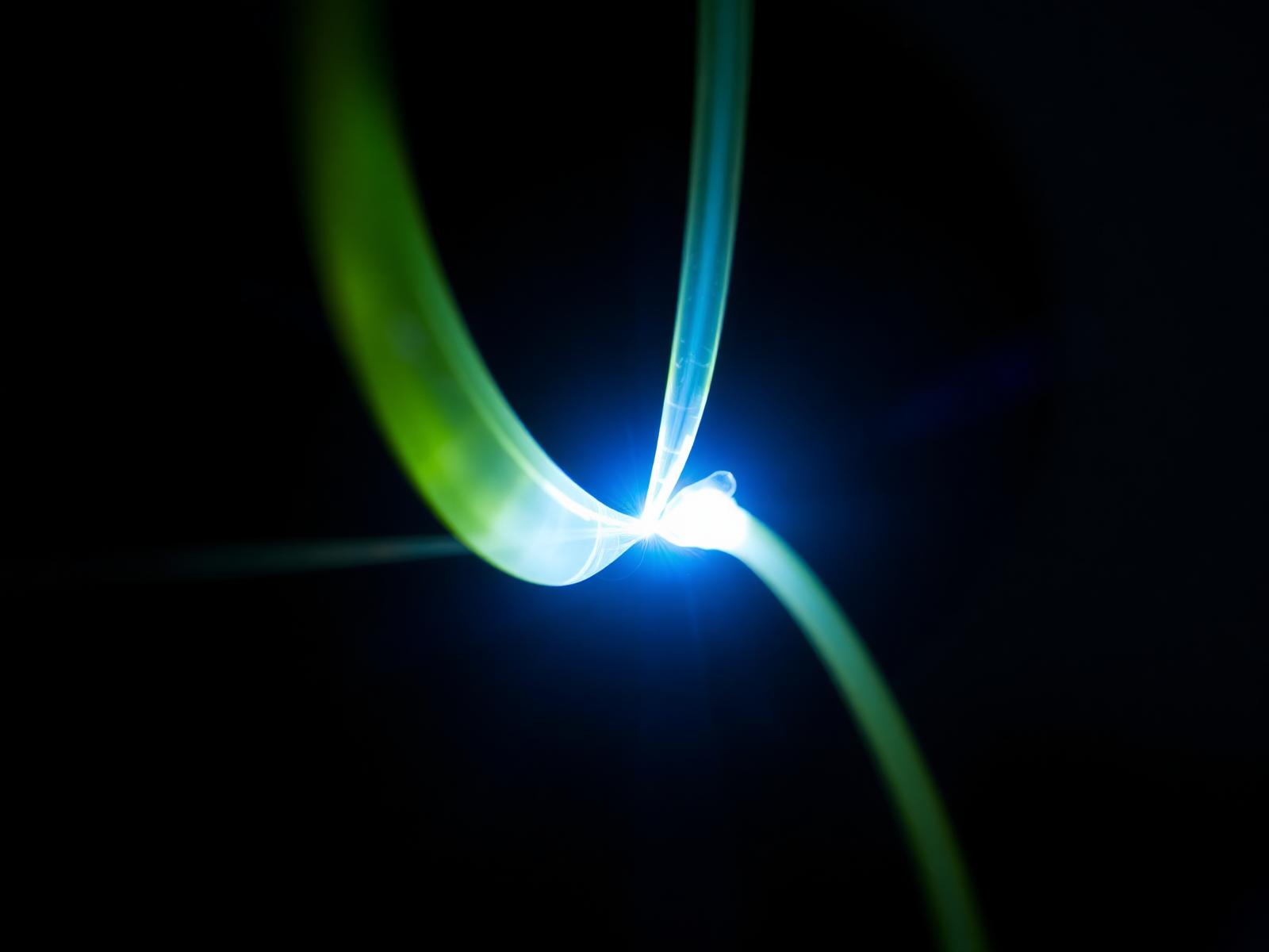 Emergency fiber splice arc between two aligned fibers during after-hours restoration.