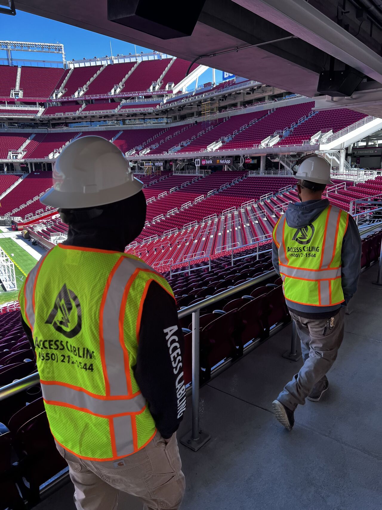 Two Access Cabling technicians on-site during a large-venue nationwide deployment.