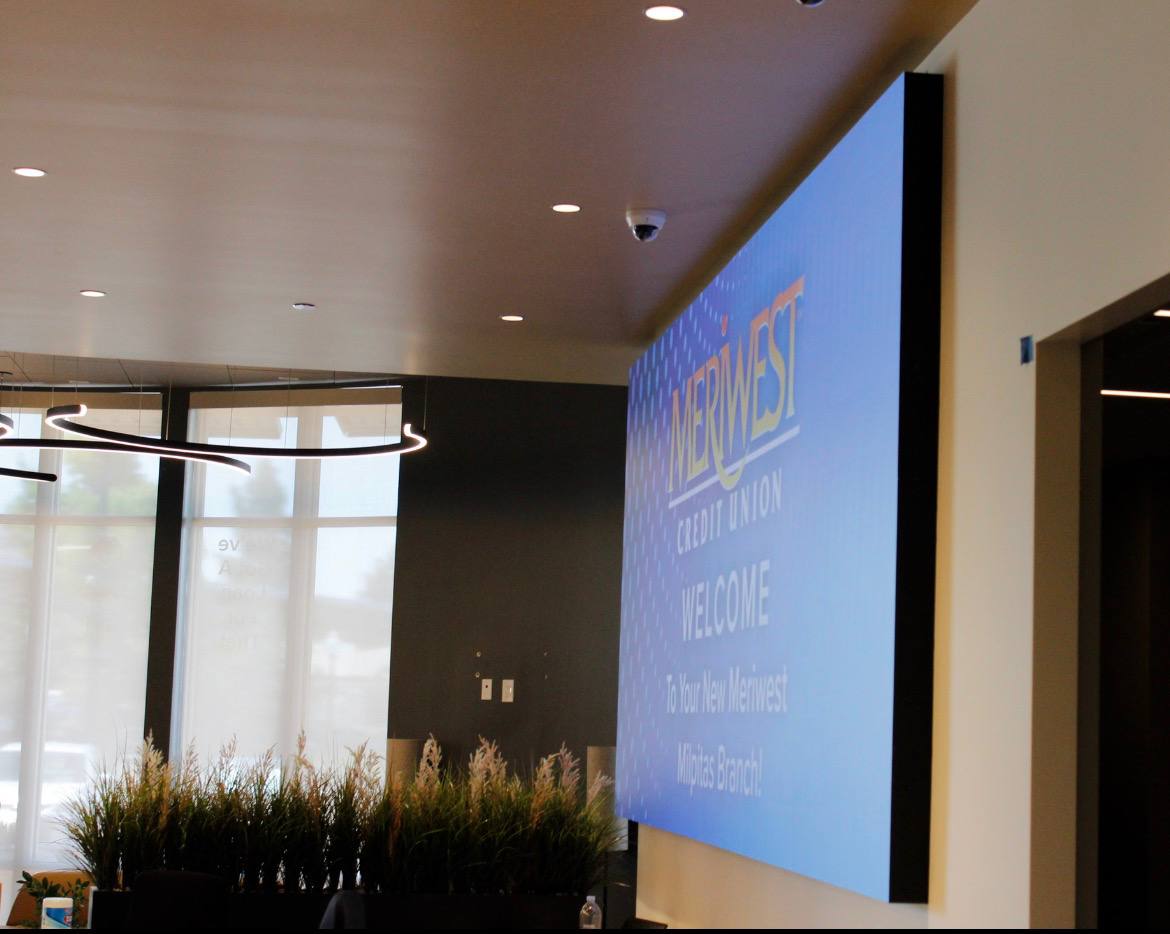 Meriwest Credit Union Milpitas LED video wall showing welcome content across the corner canvas from the branch entry