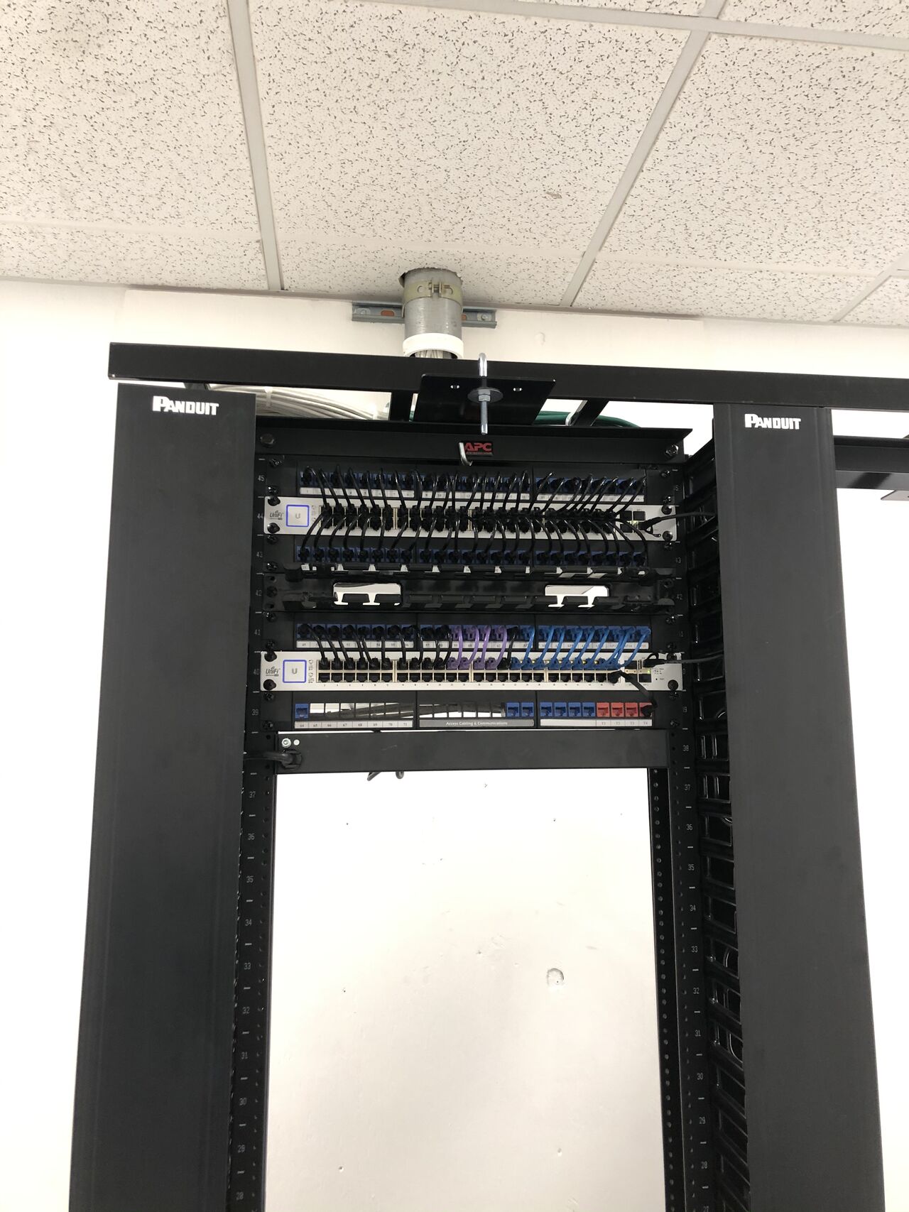 MDF patch panels dressed with color-coded Cat6 cords feeding building IDF uplinks.