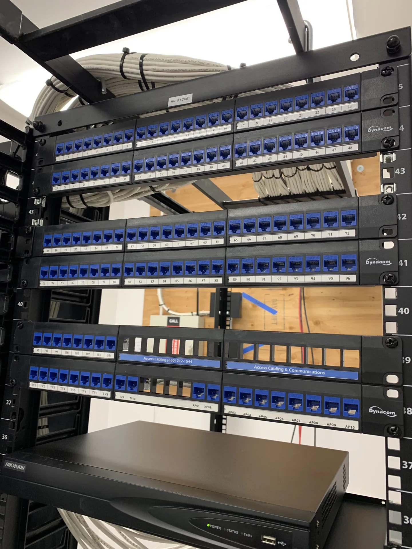 Labeled Cat6 rack terminated for TV and AP drops, certified under a 25-year manufacturer warranty.