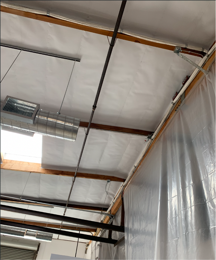 Open warehouse ceiling with exposed conduit, cable tray, and structural steel — an easy environment to route new cabling.