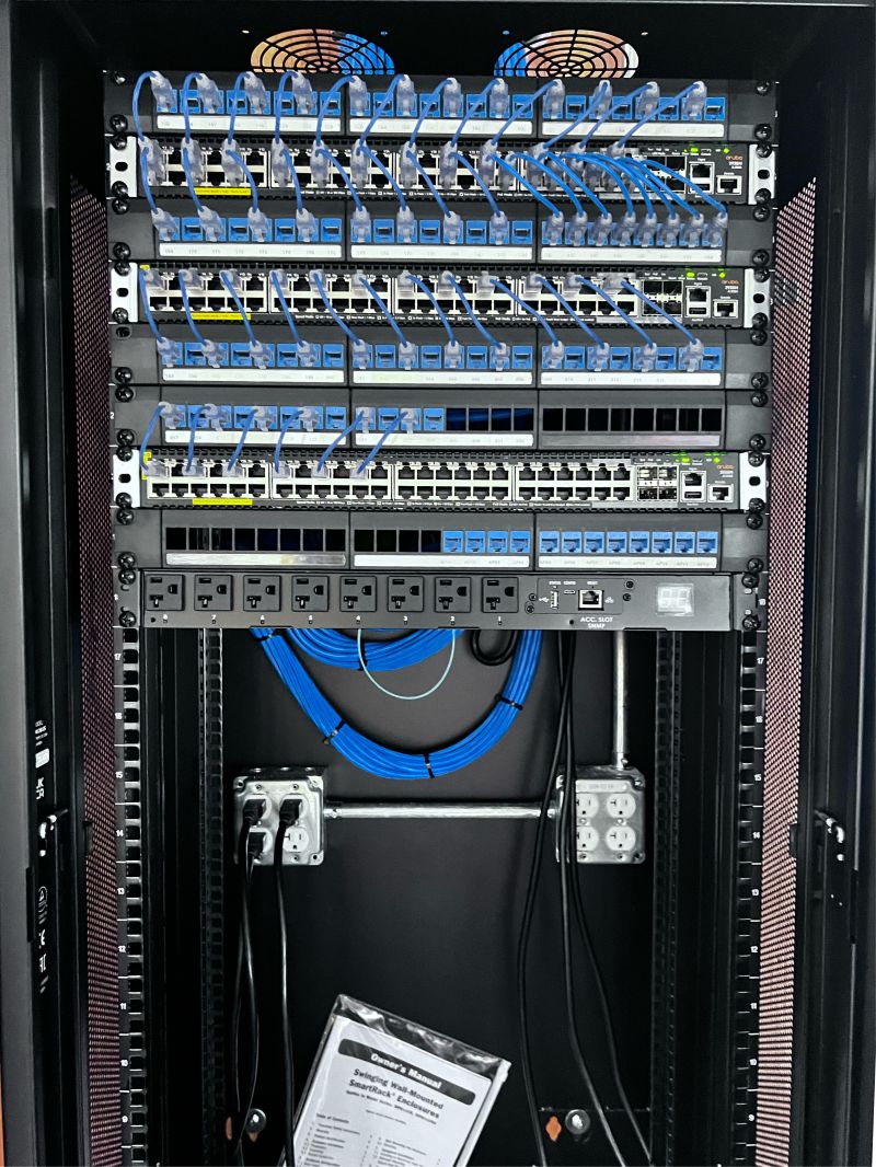 Wall-mounted enclosure with alarm panel and low-voltage terminations