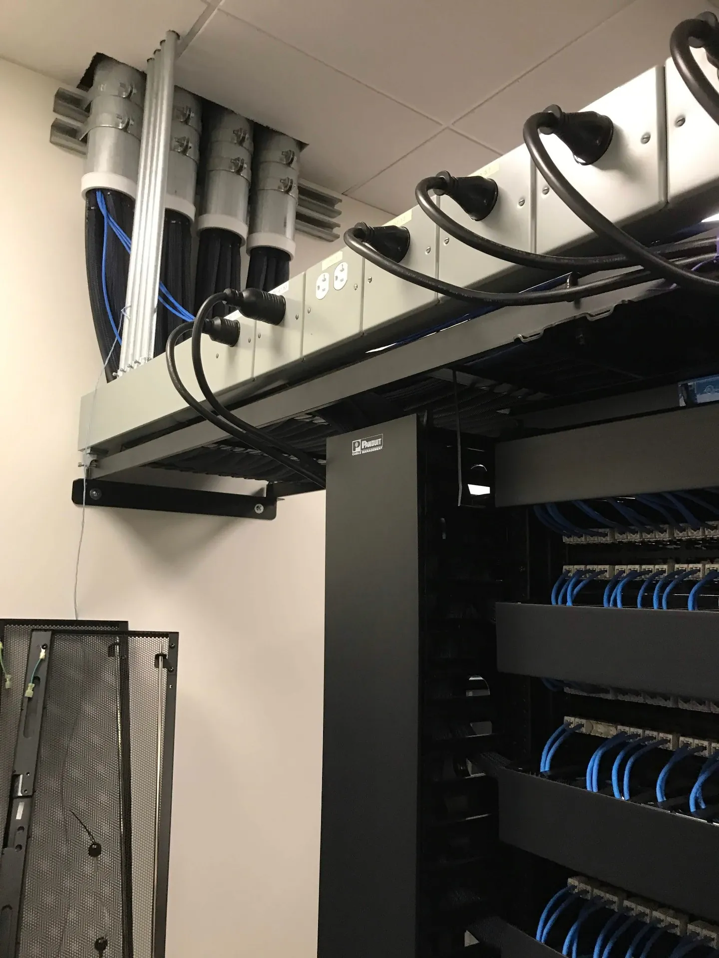 Overhead cable tray and conduit stubs prepared for outside-plant fiber entrance cabling.