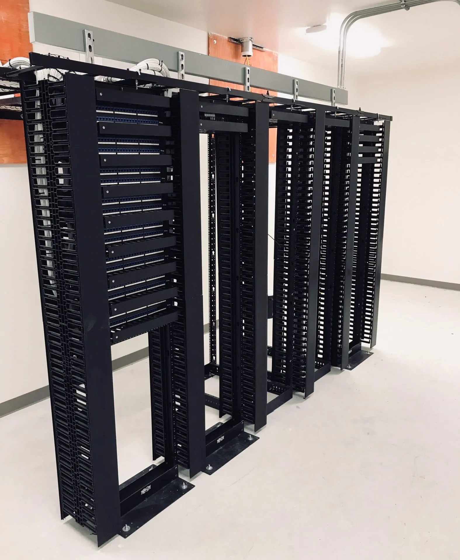 Row of enterprise data center rack elevations with front-to-rear vertical cable managers, high-density LC fiber patching and Category 6A copper distribution, installed and labeled by Access Cabling.