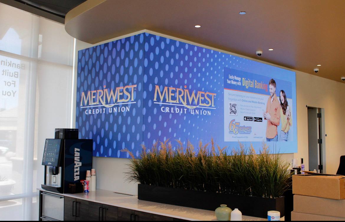 Custom SBC LED direct-view video wall wrapping a 96-degree architectural corner in the Meriwest Credit Union flagship lobby in Milpitas, California