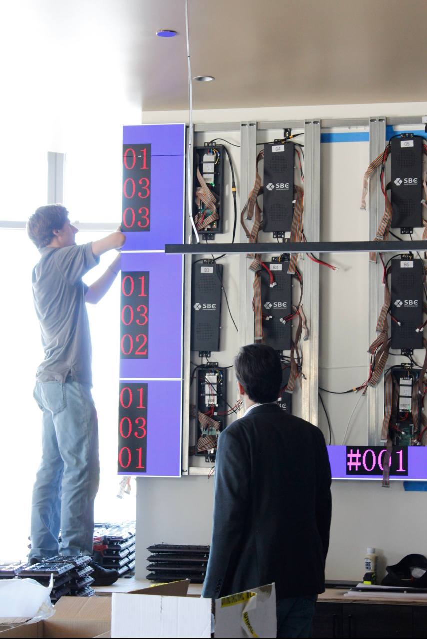 Technicians installing SBC LED cabinets and receiving cards on the sub-structure at the Meriwest Credit Union Milpitas branch