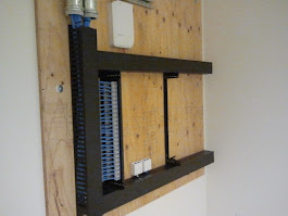 Legacy 110-block on a plywood backboard flagged for NEC 800.25 abandoned-cable removal.