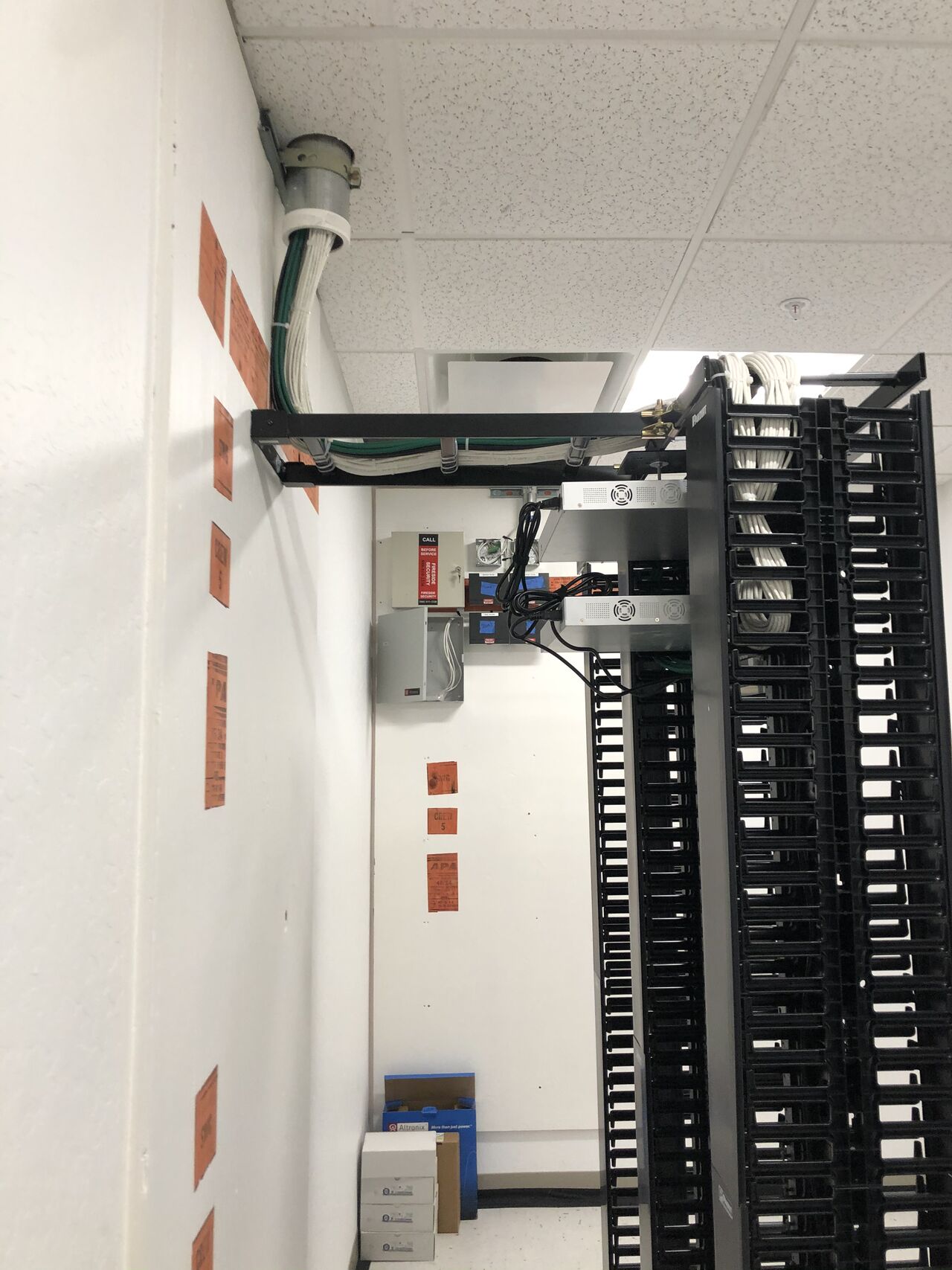 Overview of a commercial server room with two dressed Panduit racks and overhead pathway.