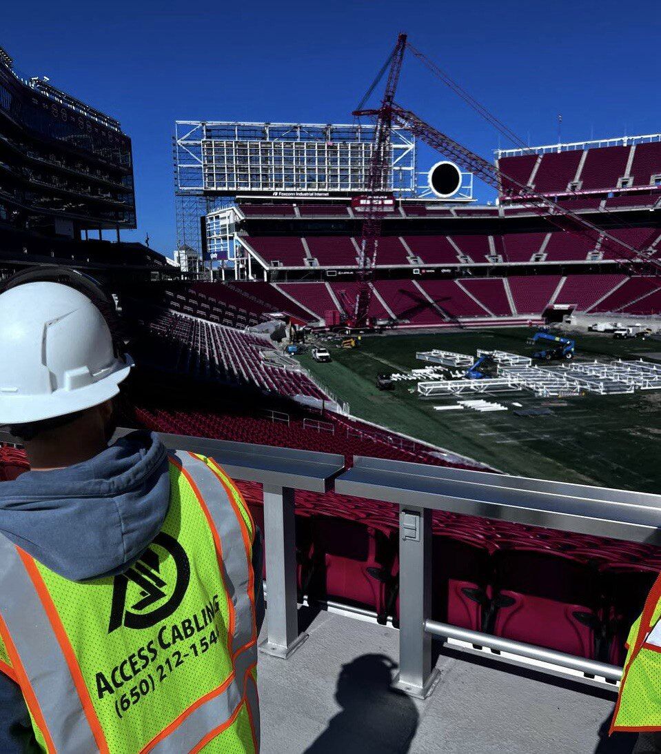 Access Cabling technician in safety vest on a commercial job site