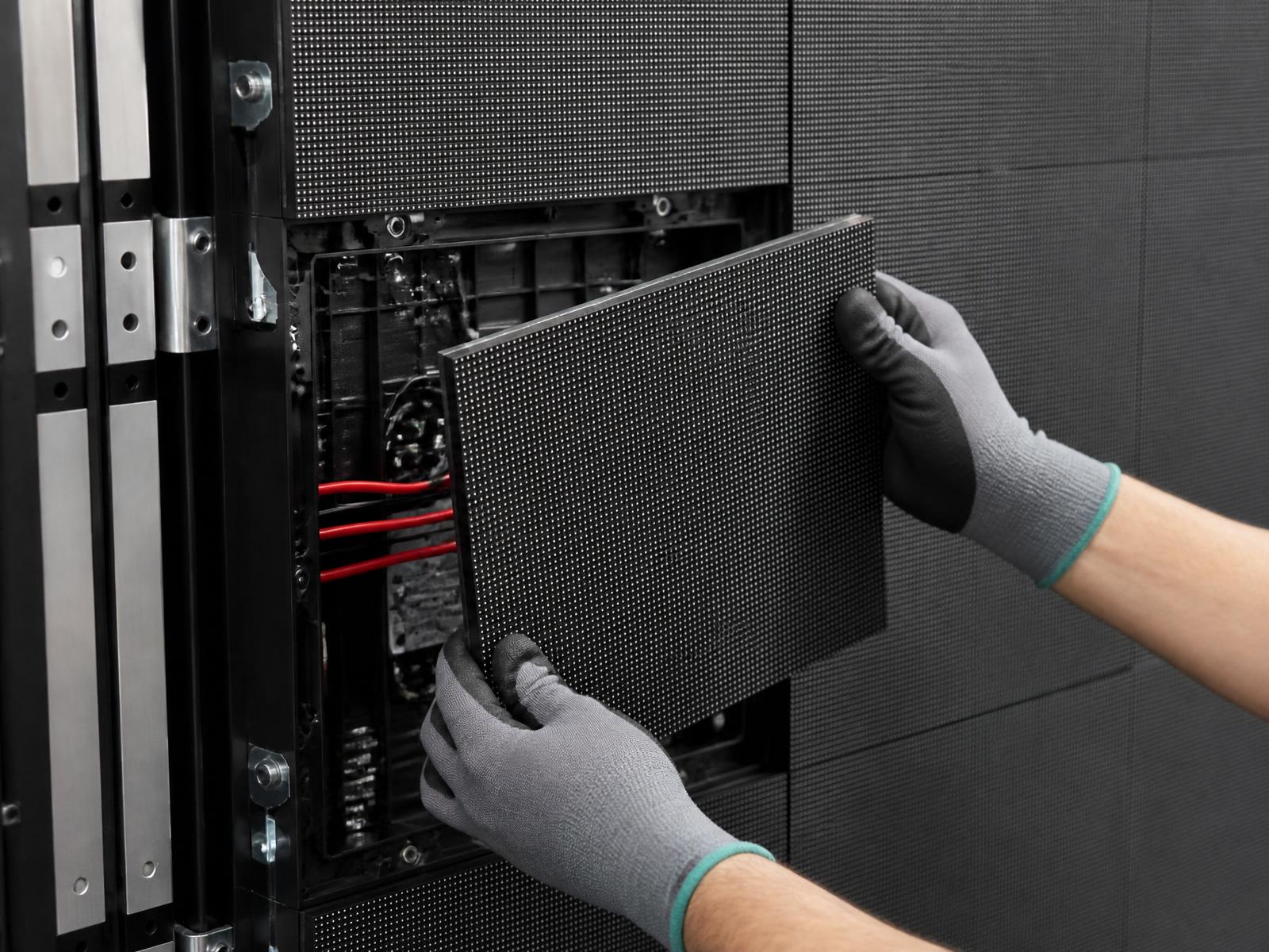 Fine-pitch DVLED module removed from the cabinet showing SMD pixel pitch and rear cabling.